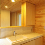 二階洗面室も木肌に囲まれロッジのような装い 白いタイル張りの洗面台