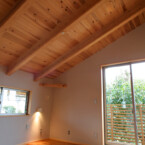 勾配天井で開放的な主寝室 無垢のフローリングと塗り壁の一室