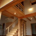 階段と一体の本棚に、洗面室への入口がある デッキより、階段と吹き抜け