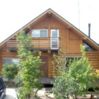 サドルノッチで組上げた日の字プランのログシェルは強度、バランスともに抜群 軒の深い大屋根が特徴のハンドカットログハウス