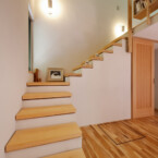 漆喰と無垢板の階段を上るとロフトにある書斎スペースへ 主寝室、壁伝いにロフトへの漆喰の階段