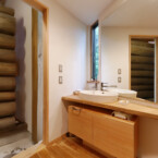 トイレのある洗面脱衣所で、変形スペースを利用し、洗面台を設置している 三角の洗面台とオーダーメイドの棚