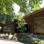 傾斜地に建つこの家は、その斜面を利用した平屋 緑あふれる季節、ルーバーとログの平屋